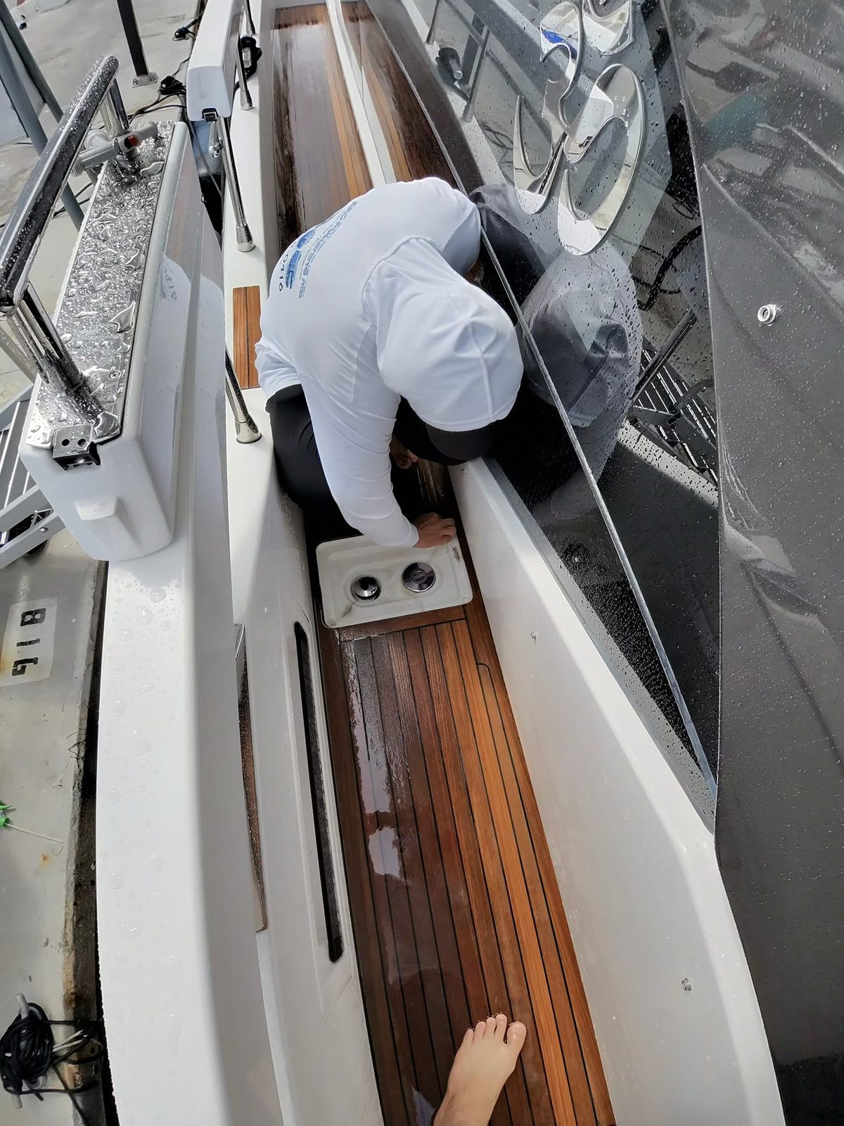 Pro Polishing MIA crew member treating a teak deck dockside