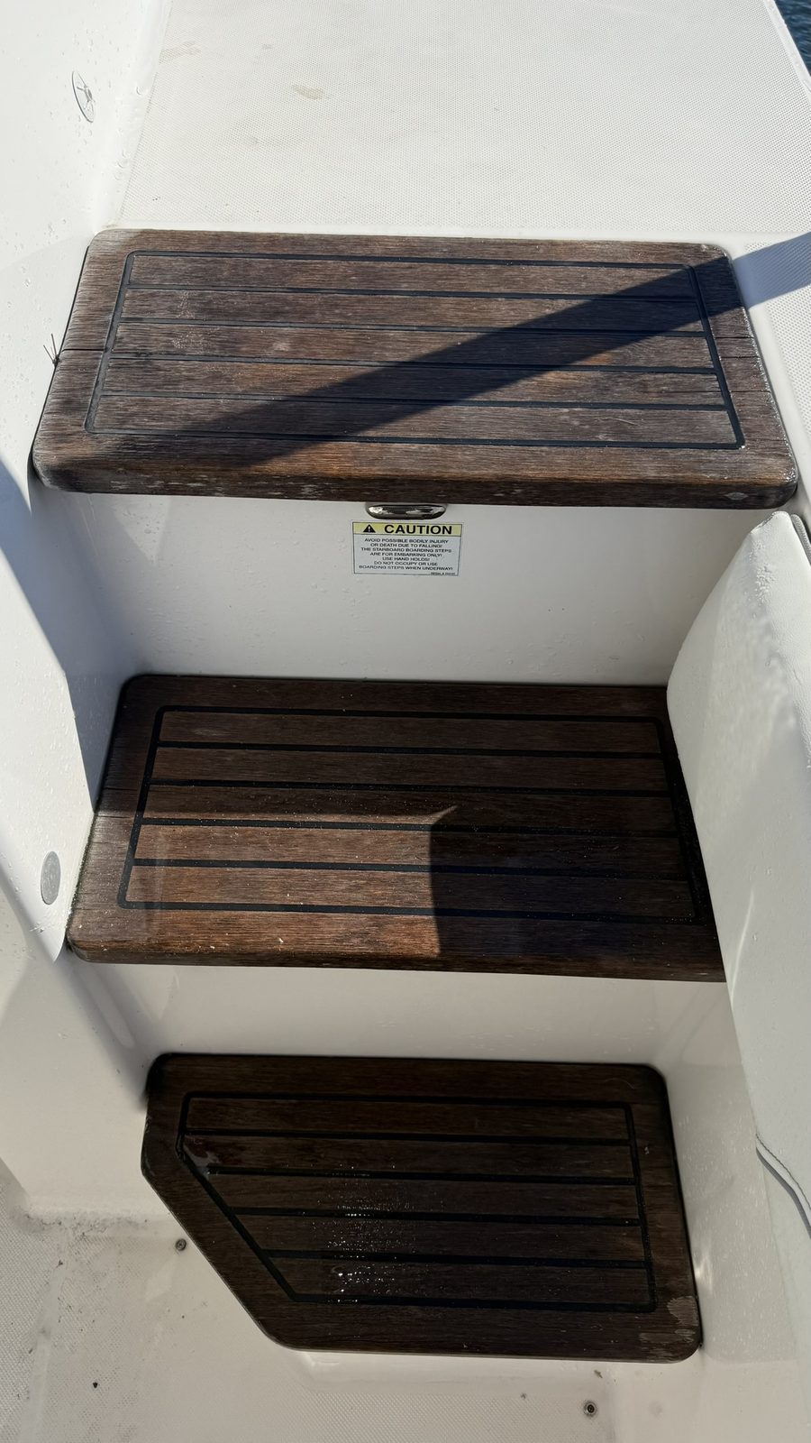Faded, weathered teak boarding steps before treatment